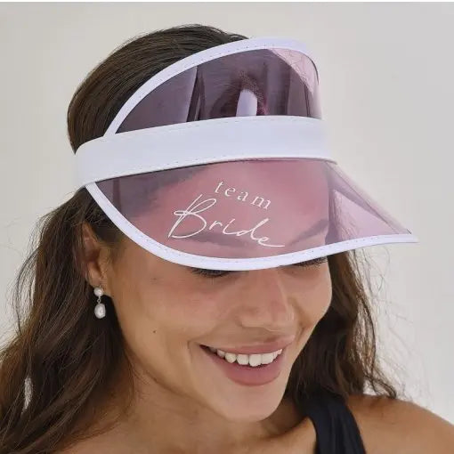 Chapéu com viseira rosa Team Bride para despedida de solteira, com detalhes decorativos na viseira e design festivo.